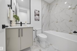 Bathroom featuring vanity, light marble finish floors, and bathtub / shower combination - 