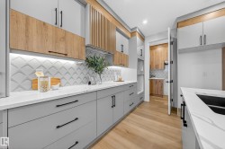 Kitchen with light wood finished floors, light stone countertops, modern cabinets, and recessed lighting - 