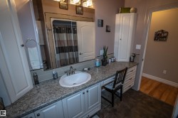 Bathroom with vanity, a shower with curtain, and dark wood-type flooring - 