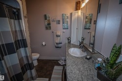 Full bathroom with vanity, curtained shower, and dark tile patterned floors - 