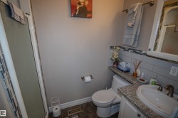 Bathroom with a shower stall, vanity, and decorative backsplash - 