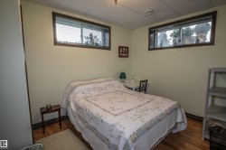Bedroom with a drop ceiling and dark wood finished floors - 