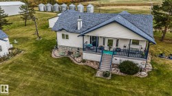 Back of property featuring a yard, a shingled roof, a wooden deck, and stairs - 