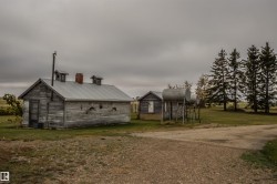 View of front of property featuring a front yard, an outdoor structure, and a chimney - 
