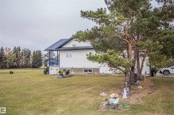 View of side of property featuring a yard and a balcony - 