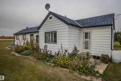 Back of house with roof with shingles and a lawn - 