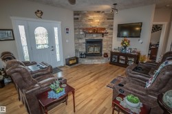Living area with a textured ceiling, light wood-type flooring, and a fireplace - 
