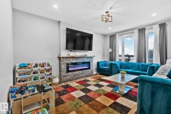 Living area with a stone fireplace and recessed lighting - 