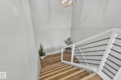 Stairway featuring radiator heating unit and wood finished floors - 
