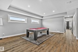 Playroom with pool table, recessed lighting, light wood-style floors, a tray ceiling, and a textured ceiling - 