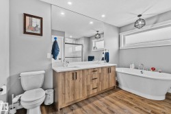 Full bath featuring a marble finish shower, double vanity, a soaking tub, light wood-style flooring, and recessed lighting - 