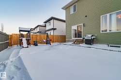 Yard layered in snow featuring a fenced backyard and entry steps - 