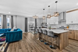 Kitchen with brown cabinets, white cabinets, open floor plan, decorative backsplash, and an island with sink - 