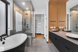 Full bath with a freestanding tub, double vanity, a stall shower, a spacious closet, and concrete flooring - 