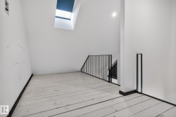 Unfurnished room with a skylight and hardwood / wood-style floors - 