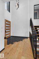 Foyer entrance with hardwood / wood-style floors, a towering ceiling, and stairs - 
