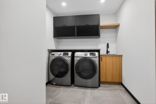 Laundry room featuring concrete floors, separate washer and dryer, and cabinet space - 104 Edgewater Circle, Leduc, AB - Indoor Photo Showing Laundry Room
