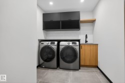 Laundry room featuring concrete floors, separate washer and dryer, and cabinet space - 