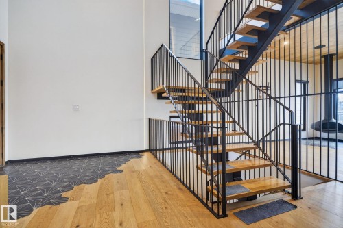 Stairway featuring wood-type flooring and a high ceiling - 104 Edgewater Circle, Leduc, AB - Indoor Photo Showing Other Room