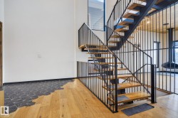 Stairway featuring wood-type flooring and a high ceiling - 