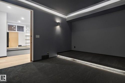 Empty room with dark carpet and recessed lighting - 104 Edgewater Circle, Leduc, AB - Indoor Photo Showing Other Room