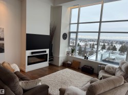 Living room with a glass covered fireplace and wood finished floors - 
