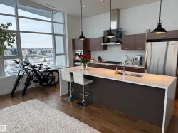 Kitchen featuring dark brown cabinetry, modern cabinets, an island with sink, decorative backsplash, and dark wood-style flooring - 