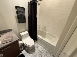 Bathroom with vanity, shower / bath combo, and marble finish flooring - 