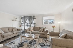 Living area featuring a textured ceiling, wood finished floors, and ornamental molding - 