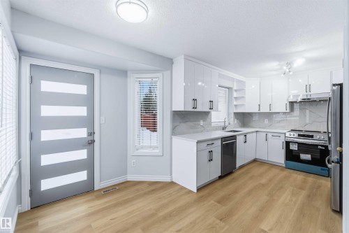 Kitchen featuring open shelves, stainless steel appliances, white cabinetry, backsplash, and a textured ceiling - 115 Deer Ridge Drive, St. Albert, AB - Indoor Photo Showing Kitchen
