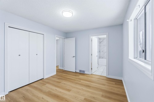 Unfurnished bedroom with ensuite bath, light wood-type flooring, a textured ceiling, and a closet - 115 Deer Ridge Drive, St. Albert, AB - Indoor Photo Showing Other Room