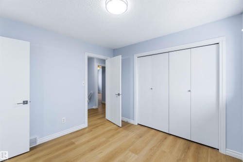 Unfurnished bedroom with a textured ceiling, light wood-style floors, and a closet - 115 Deer Ridge Drive, St. Albert, AB - Indoor Photo Showing Other Room