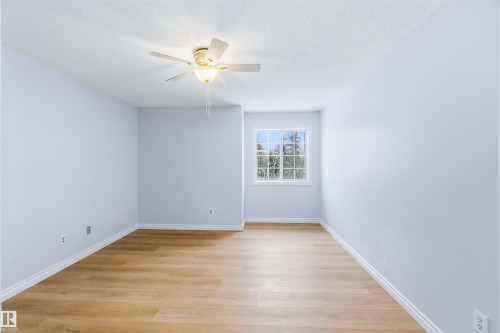Empty room with light wood-style flooring, a textured ceiling, and ceiling fan - 115 Deer Ridge Drive, St. Albert, AB - Indoor Photo Showing Other Room
