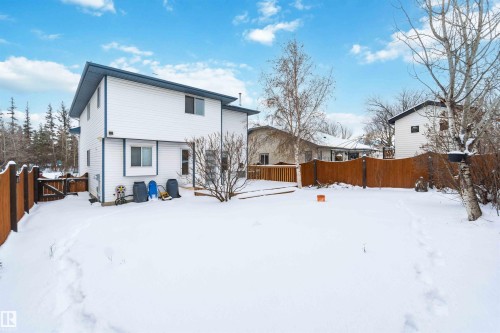 Snow covered rear of property featuring a fenced backyard, a gate, and a deck - 115 Deer Ridge Drive, St. Albert, AB - Outdoor