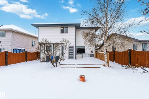 Snow covered back of property featuring a fenced backyard and a deck - 115 Deer Ridge Drive, St. Albert, AB - Outdoor