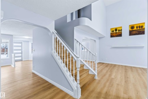 Staircase with a textured ceiling, arched walkways, and wood finished floors - 115 Deer Ridge Drive, St. Albert, AB - Indoor Photo Showing Other Room