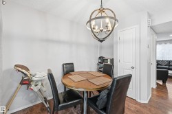 Dining space featuring a textured ceiling, dark wood-style floors, and a chandelier - 
