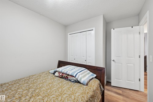 Bedroom with a textured ceiling, a closet, and wood finished floors - 21017 60 Avenue, Edmonton, AB - Indoor Photo Showing Bedroom