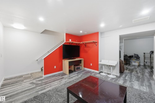 Recreation room with light wood finished floors, recessed lighting, and stairway - 21017 60 Avenue, Edmonton, AB - Indoor With Fireplace