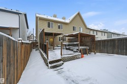 Snow covered house featuring a fenced backyard and a wooden deck - 