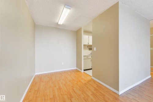 Spare room featuring light wood-style floors and a textured ceiling - 601 13910 Stony Plain Road, Edmonton, AB - Indoor Photo Showing Other Room