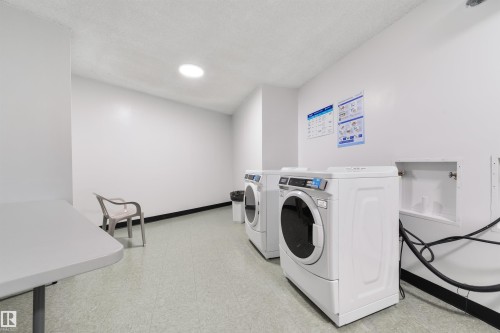 Community laundry featuring a textured ceiling and independent washer and dryer - 601 13910 Stony Plain Road, Edmonton, AB - Indoor Photo Showing Laundry Room