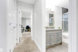 Hallway featuring light colored carpet and baseboards - 