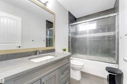 Bathroom featuring shower / bath combination with glass door, vanity, a textured ceiling, and light wood-type flooring - 