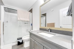 Full bathroom with a stall shower, vanity, a textured ceiling, and light wood-style floors - 