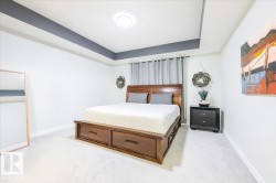 Bedroom featuring light carpet and a raised ceiling - 
