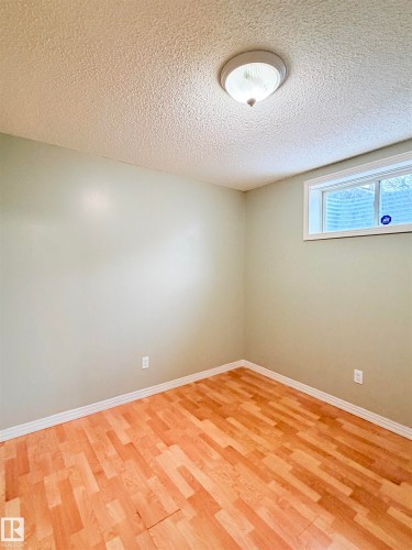 Unfurnished room featuring light wood-type flooring and a textured ceiling - 1711 37A Avenue, Edmonton, AB - Indoor Photo Showing Other Room