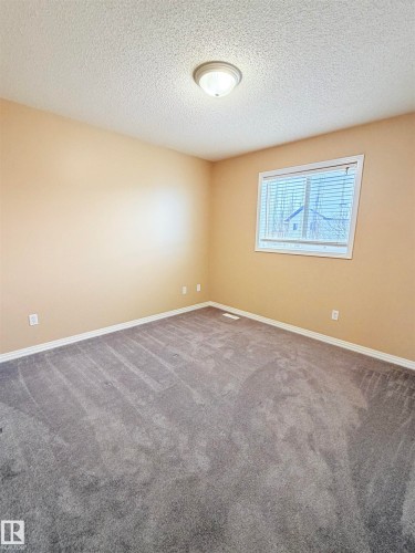Unfurnished room featuring a textured ceiling and carpet floors - 1711 37A Avenue, Edmonton, AB - Indoor Photo Showing Other Room