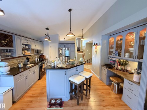 Kitchen featuring vaulted ceiling, a kitchen bar, decorative backsplash, decorative light fixtures, and stainless steel appliances - 62 Willowby Close, Stony Plain, AB - Indoor Photo Showing Kitchen With Upgraded Kitchen