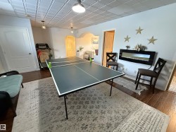 Game room with arched walkways and dark wood-type flooring - 